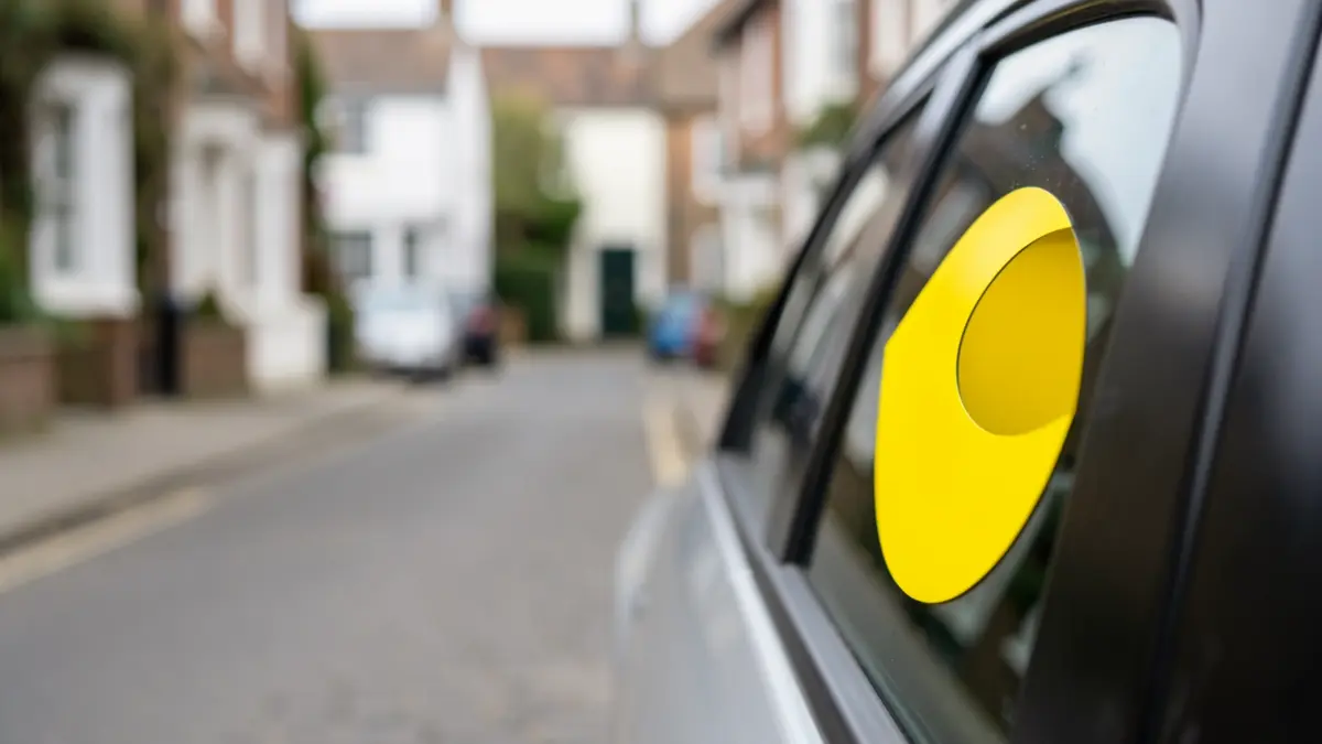Generic image of a yellow half-moon taxi sign on a car door.